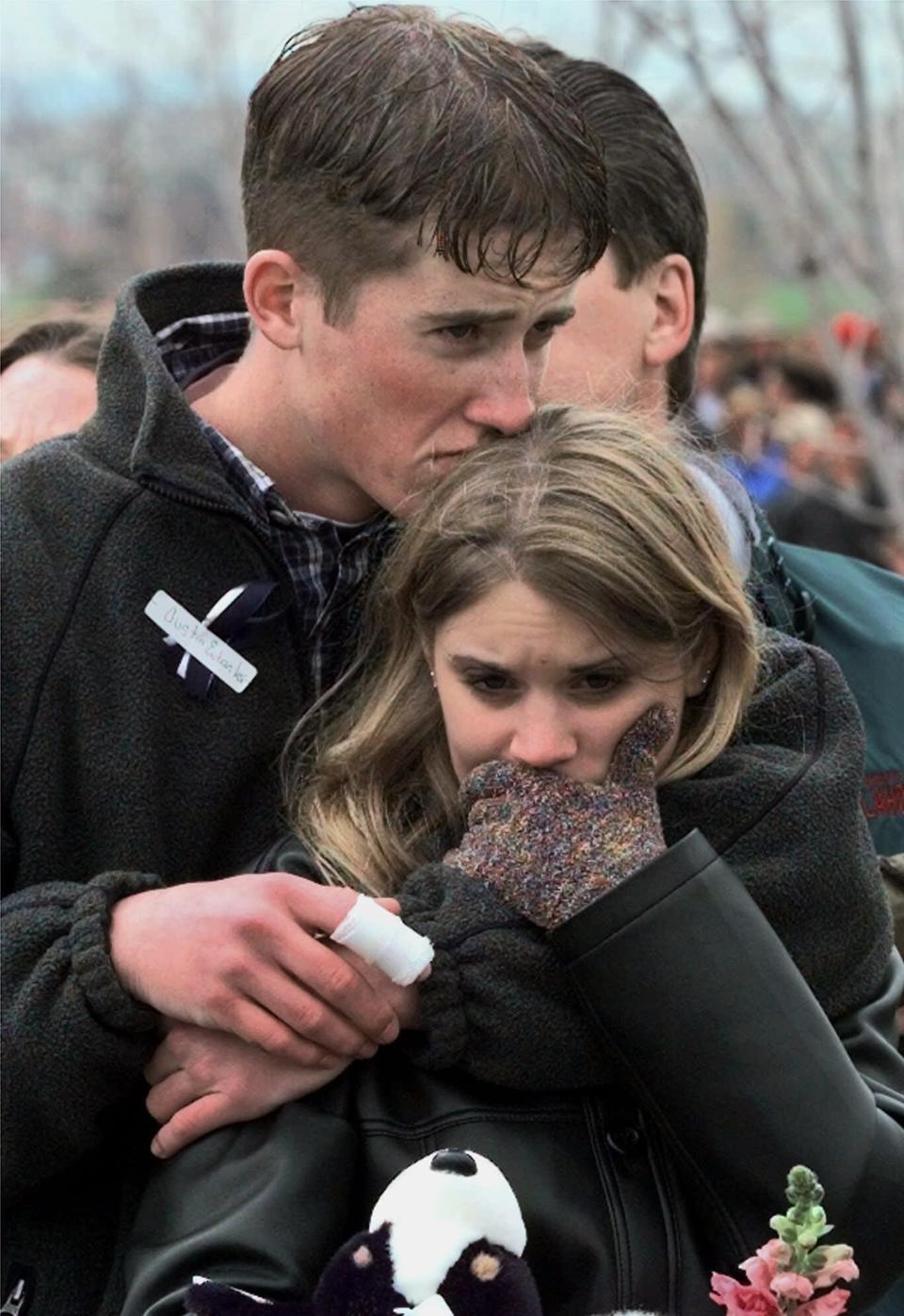 In this April 25, 1999 file photo, shooting victim Austin Eubanks hugs his girlfriend during a community wide memorial service in Littleton, Colo., for the victims of the shooting rampage at Columbine High School the previous week. Eubanks, who survived the 1999 Columbine school shooting and later became an advocate for fighting addiction has died. Routt County Coroner Robert Ryg said Saturday, May 18, 2019, that 37-year-old Eubanks died overnight at his Steamboat Springs home. A Monday autopsy was planned to determine the cause of death. (AP Photo/Bebeto Matthews, File)