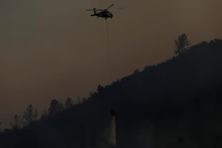 A helicopter makes a water drop on a hot spot during the Detwiler fire in Mariposa, California U.S. July 19, 2017. REUTERS/Stephen Lam