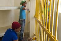 Prisoners paint their cell inside the renovated wing of the Najayo women's prison in San Cristobal, May 12, 2014. Ten years after the country opened its first prison designed with a focus on education and clean living conditions and staffed by graduates from a newly created academy for penitentiary studies, the New Model of Prison Management is gaining recognition from other countries in the region trying to reduce prison populations and cut recidivism rates. Picture taken May 12, 2014. REUTERS/Ricardo Rojas (DOMINICAN REPUBLIC - Tags: CRIME LAW POLITICS SOCIETY)