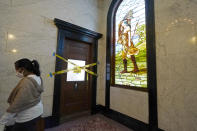 FILE - In this Feb. 23, 2021, file photo, a visitor walks past the taped-off women's restroom on the third floor of the Mississippi State Capitol in Jackson, Miss. The snow and ice that crippled some states across the South has melted. But it has exposed the fragility of aging waterworks that experts have been warning about for years. Cities across Texas, Tennessee, Louisiana and Mississippi are still grappling with outages that crippled health care facilities and forced families to wait in line for potable water. (AP Photo/Rogelio V. Solis, File)