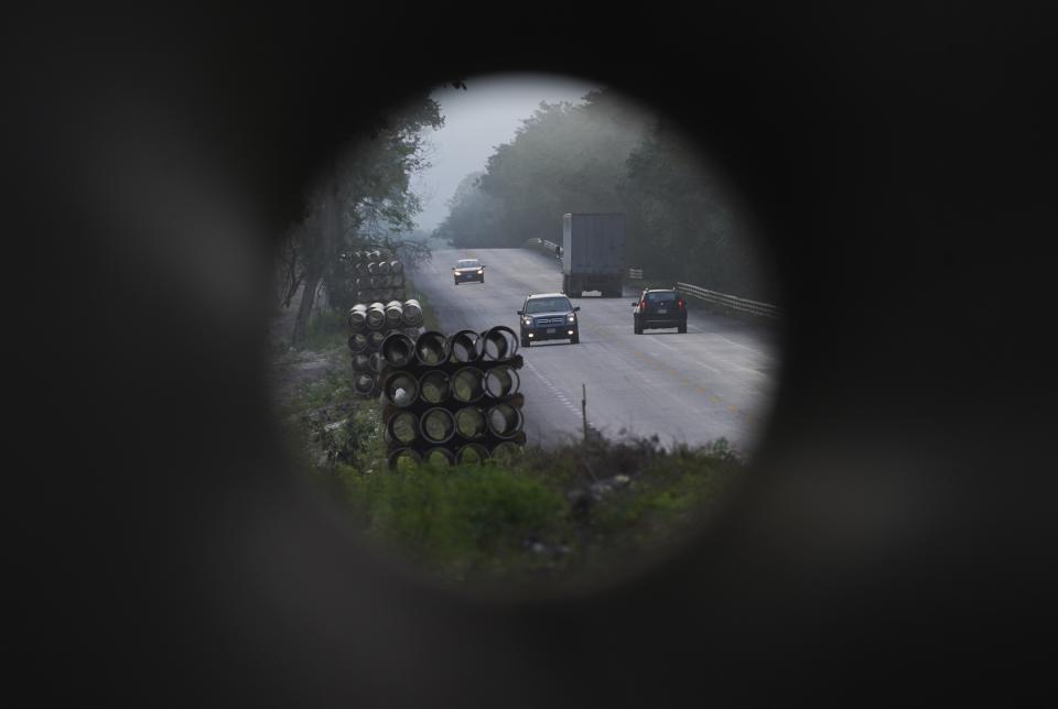 Cars on a road near Xpujil, Mexico, can be seen through pipes to restore the local water main on Wednesday, Jan. 11, 2023. A major rail project in the Yucatan Peninsula, called the Maya Train, is intended to drive economic development to some of the country’s poorest areas, in part by bringing up to three million tourists each year. (AP Photo/Marco Ugarte)