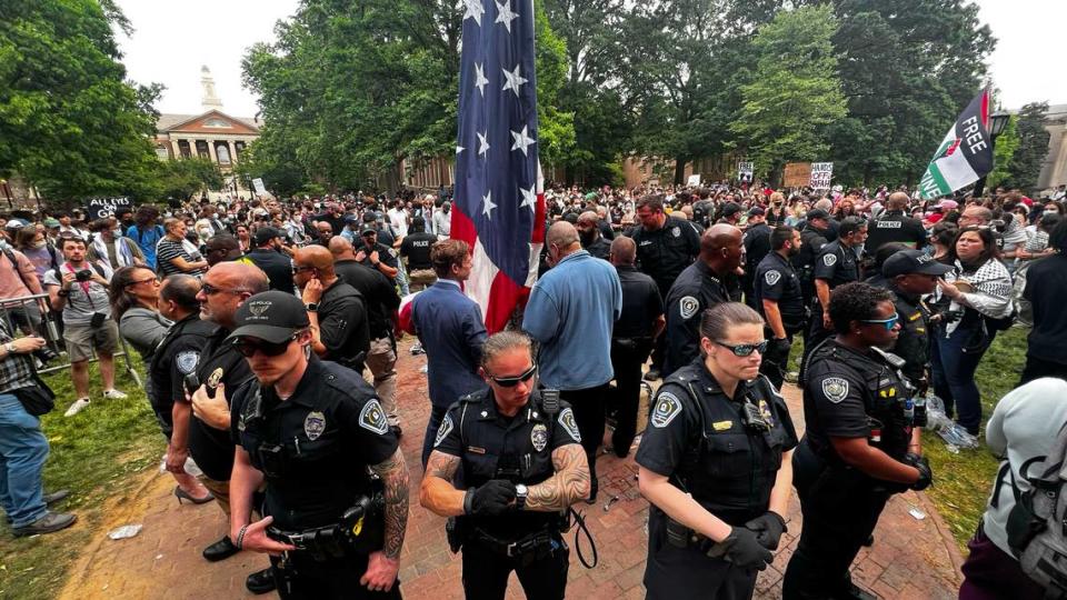 UNC interim chancellor Lee Roberts (center left), prepares to raise the United States flag after protesters replaced in with a Palestinian flag during protests on campus, Tuesday, April 20, 2024.