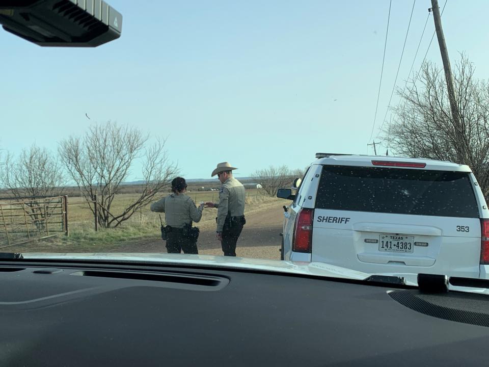 Deputy Sarah Steele consults with another officer at a traffic stop on a small county road.