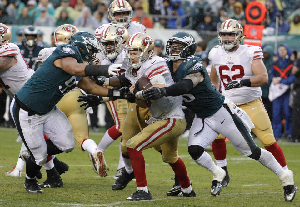 FILE - In this Oct. 29, 2017, file photo, Philadelphia Eagles' Destiny Vaeao (97) and Chris Long (56) take down San Francisco 49ers' C.J. Beathard during the second half of an NFL football game in Philadelphia. Long has announced his retirement from football, ending an 11-year NFL playing career that included winning two Super Bowl titles and the Walter Payton Man of the Year Award. Long posted his decision Saturday night, May 18, on Twitter, saying it has "been a hell of a journey" and adds that "I can honestly say I put my soul into every minute of it." (AP Photo/Chris Szagola, File)