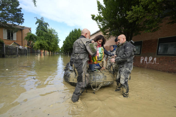 People are rescued in Faenza, Italy, Thursday, May 18, 2023. Exceptional rains Wednesday in a drought-struck region of northern Italy swelled rivers over their banks, killing at least nine people, forcing the evacuation of thousands and prompting officials to warn that Italy needs a national plan to combat climate change-induced flooding. (AP Photo/Luca Bruno)