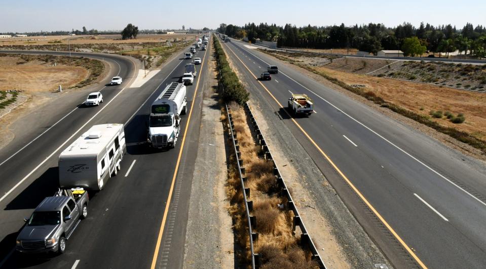 Cars and trucks zoom along Highway 99 under the Cartmill Avenue bridge on Monday afternoon. Plans to widen the freeway in Tulare and Madera County to six lanes have been canceled by the California Department of Transportation.