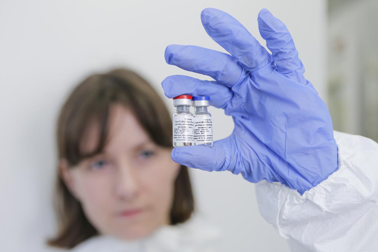 In this handout photo taken on Thursday, Aug. 6, 2020, and provided by Russian Direct Investment Fund, an employee shows a new vaccine at the Nikolai Gamaleya National Center of Epidemiology and Microbiology in Moscow, Russia. Russia on Tuesday, Aug. 11 became the first country to approve a coronavirus vaccine for use in tens of thousands of its citizens despite international skepticism about injections that have not completed clinical trials and were studied in only dozens of people for less than two months. (Alexander Zemlianichenko Jr/ Russian Direct Investment Fund via AP)