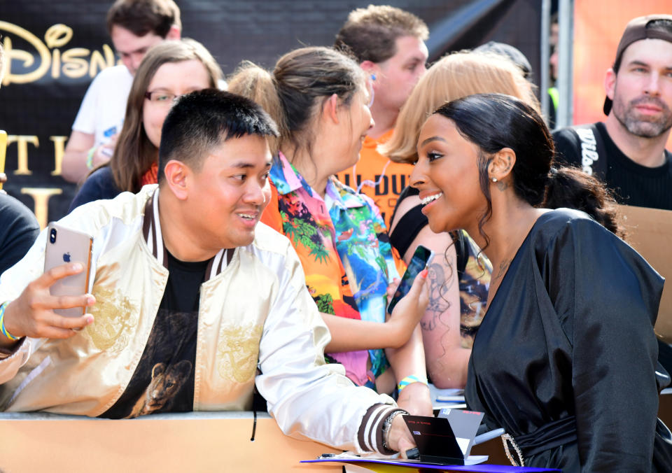 Alexandra Burke poses for a photograph with a fan during Disney's The Lion King European Premiere held in Leicester Square, London.