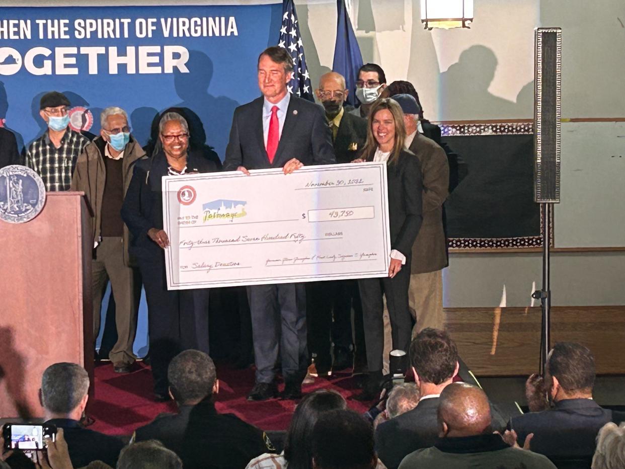 From left, Pathways CEO Juanita Epps, Gov. Glenn Youngkin and First Lady Suzanne Youngkin display the ceremonial check of $43,750 that the Youngkins donated to the Petersburg nonprofit Wednesday, Nov. 30, 2022.