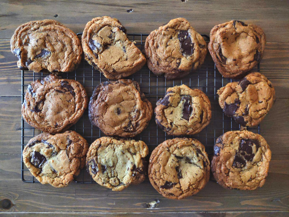 Freshly baked chocolate chip cookies on a rack.