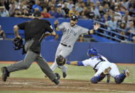 Seattle Mariners base runner Dustin Ackley (C) scores a run ahead of the tag by Toronto Blue Jays catcher J.P. Arencibia (R) as home plate umpire Paul Emmel follows the play during the fourth inning of their MLB American League baseball game in Toronto September 12, 2012. REUTERS/Mike Cassese (CANADA - Tags: SPORT BASEBALL TPX IMAGES OF THE DAY)