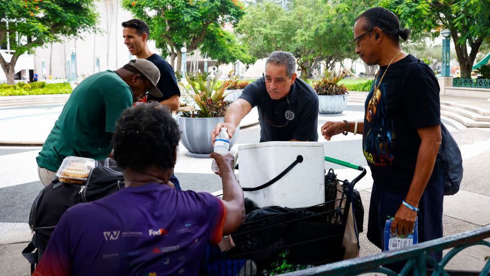 Miami-Dade County Homeless Trust representatives distribute bottles of water and shelter information during a heat wave in Miami, Florida, on July 25, 2023.  - Eva Marie Uzcategui/Bloomberg/Getty Images