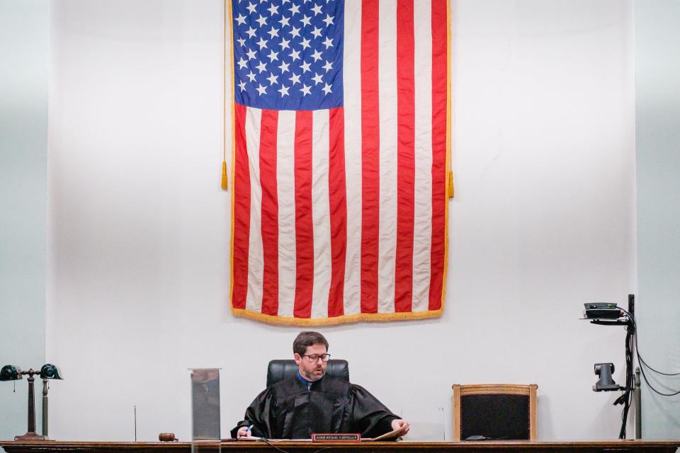 Carroll County Common Pleas Judge Michael V. Repella II handles court papers Thursday during the arraignment of former Carrollton Superintendent David Quattrochi, board member Michael Pozderac, teacher Mary "Jackie" Pozderac and Canton business owner Gus Nickolas for a series of theft-related charges involving Carrollton Exempted Village Schools.