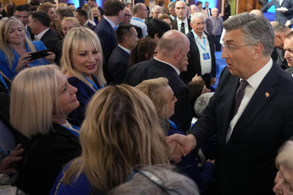 Prime Minister incumbent Andrej Plenkovic, right, shakes hands with his supporters after claiming victory in a parliamentary election in Zagreb, Croatia, Thursday, April 18, 2024. Croatia's governing conservatives convincingly won a highly contested parliamentary election Wednesday, but will still need support from far-right groups to stay in power, according to the official vote count. The election followed a campaign that centered on a bitter rivalry between the country's president and prime minister. (AP Photo/Darko Vojinovic)