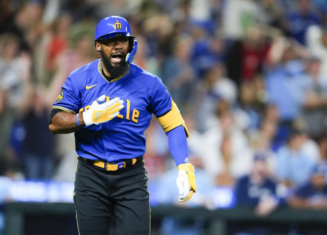 Seattle Mariners' J.P. Crawford (3) holds a trident after hitting a home  run as he is greeted by teammate Teoscar Hernández, left, against the  Kansas City Royals during the first inning of