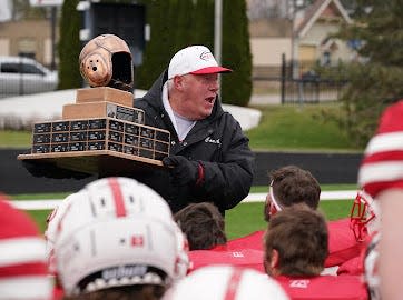 Ripon coach Ron Ernst holds up the Doehling-Heselton Trophy after the Red Hawks beat Lawrence on Saturday in his final game as head coach.