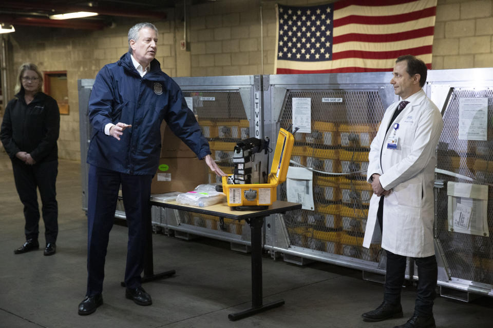 New York City Mayor Bill de Blasio, left, discusses the arrival of a shipment of 400 ventilators with Dr. Steven Pulitzer, the Chief Medical Officer of NYC Health and Hospitals, at the city's Emergency Management Warehouse, Tuesday, March 24, 2020, in New York. (AP Photo/Mark Lennihan)