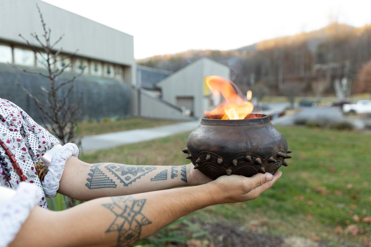 A traditional Cherokee firepot holds a flame in front of what is now the newly rebranded Museum of the Cherokee People in Cherokee. Museum exhibitions present both new works by contemporary artists and cultural objects that date back thousands of years.