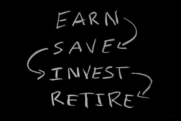 On a blackboard are four words, each pointing to the next: earn, save, invest, retire