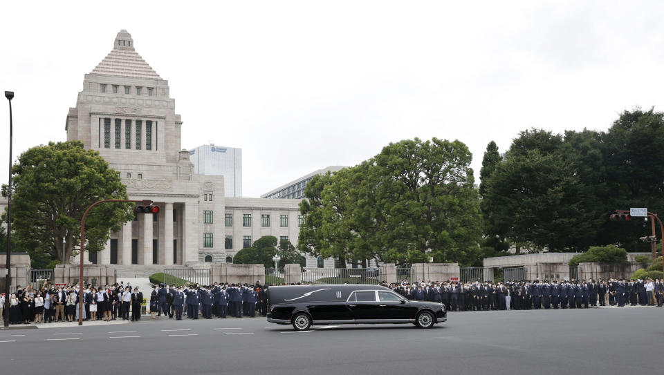 A hearse carrying the body of former Prime Minister Shinzo Abe, moves past the House of Parliament after his funeral Tuesday, July 12, 2022, in Tokyo.(Kyodo News via AP)