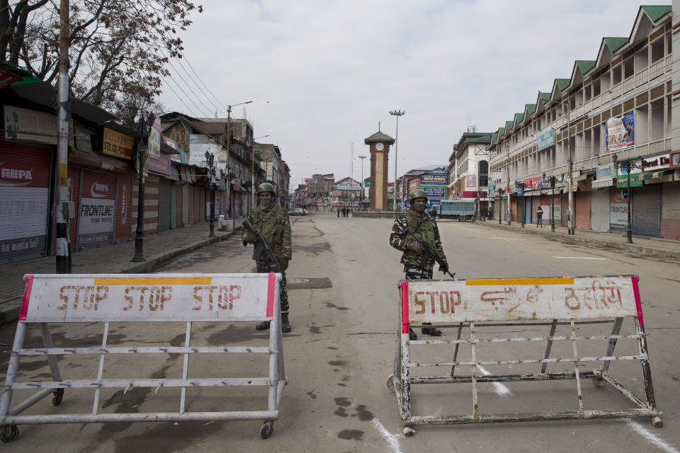 Indian paramilitary soldiers stand guard near a temporary check point during a strike in Srinagar, Indian controlled Kashmir, Sunday, Feb. 3, 2019. India's prime minster is in disputed Kashmir for a daylong visit Sunday to review development work as separatists fighting Indian rule called for a shutdown in the Himalayan region. (AP Photo/Dar Yasin)