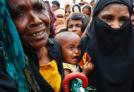 <p>A Rohingya refugee baby cries as his mother jostles for aid in Cox’s Bazar, Bangladesh, Sept. 20, 2017. (Photo: Danish Siddiqui/Reuters) </p>