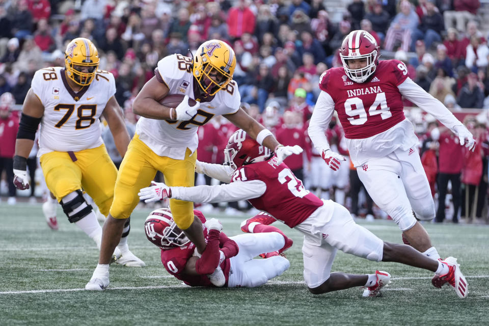 Minnesota tight end Brevyn Spann-Ford (88) is tackled by Indiana defenders Raheem Layne II (0) and Noah Pierre (21) in the first half during an NCAA college football game in Bloomington, Ind., Saturday, Nov. 20, 2021. (AP Photo/AJ Mast)