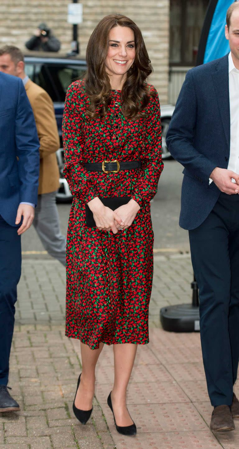 <p>Duchess Kate attends a Christmas party for volunteers at the Mix wearing a festive red-and-green printed Vanessa Seward dress with a simple black clutch and pumps. </p>