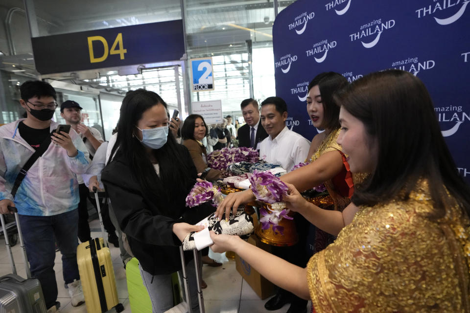 Chinese tourists received garland during welcome Chinese tourists arrive at Suvarnabhumi International Airport in Samut Prakarn province, Thailand, Monday, Sept. 25, 2023. Thailand's new government granting temporary visa-free entry to Chinese tourists, signaling that the recovery of the country's tourism industry is a top economic priority. (AP Photo/Sakchai Lalit)