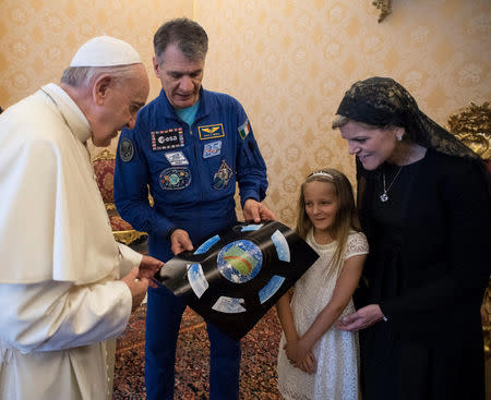 Pope Francis receives a picture from Italian astronaut Paolo Nespoli, flanked by his family, during a private meeting with crew members of the ISS 53 space mission at the Vatican June 8, 2018. Vatican Media/Handout via REUTERS