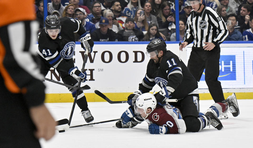Tampa Bay Lightning right wing Mitchell Chaffee (41) and center Luke Glendening (11) work against Colorado Avalanche center Ross Colton (20) for the puck during the second period of an NHL hockey game Thursday, Feb. 15, 2024, in Tampa, Fla. (AP Photo/Jason Behnken)