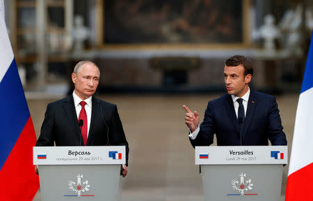 French President Emmanuel Macron (R) and Russian President Vladimir Putin (L) give a joint press conference at the Chateau de Versailles before the opening of an exhibition marking 300 years of diplomatic ties between the two countries in Versailles, France, May 29, 2017. REUTERS/Philippe Wojazer