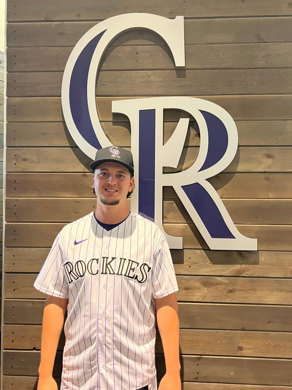 Kent State first baseman and Massillon product Aidan Longwell poses with the Colorado Rockies logo after signing his professional contract.