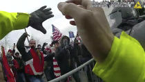 This still frame from Metropolitan Police Department body worn camera video shows Thomas Webster, in red jacket, at a barricade line at on the west front of the U.S. Capitol on Jan. 6, 2021, in Washington. Webster, a Marine Corps veteran and retired New York City Police Department Officer, is accused of assaulting an MPD officer with a flagpole. A number of law enforcement officers were assaulted while attempting to prevent rioters from entering the U.S. Capitol. (Metropolitan Police Department via AP)