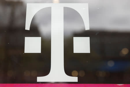 A T-Mobile logo is seen on the storefront door of a store in Manhattan, New York, U.S., April 30, 2018. REUTERS/Shannon Stapleton/File Photo