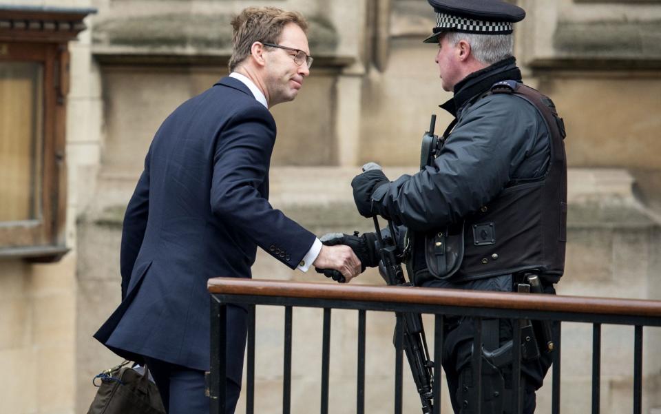 Tobias Ellwood, who gave first aid to fatally wounded Keith Palmer, shakes hands with an armed police officer outside Parliament on Friday morning - Credit: CHRIS J RATCLIFFE/AFP