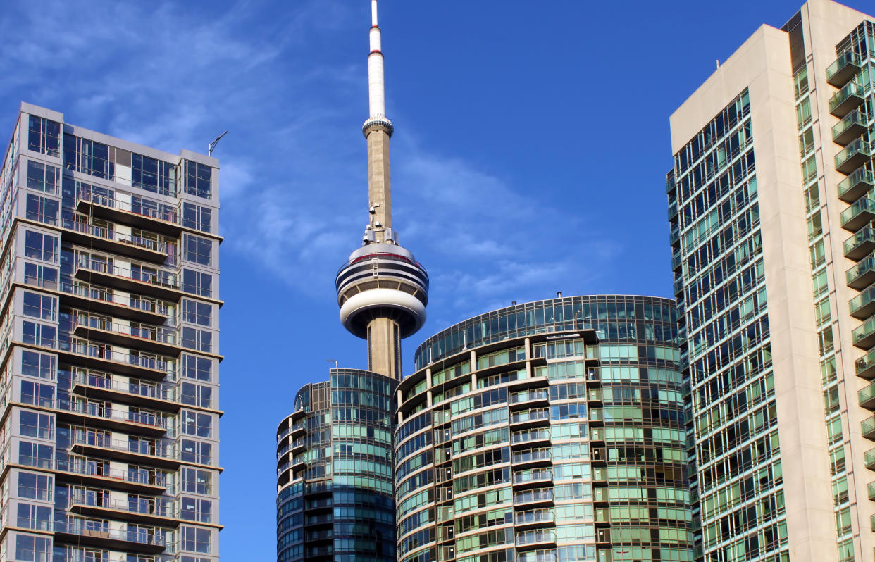 CN Tower and residential buildings against blue sky, Toronto, Ontario, Canada