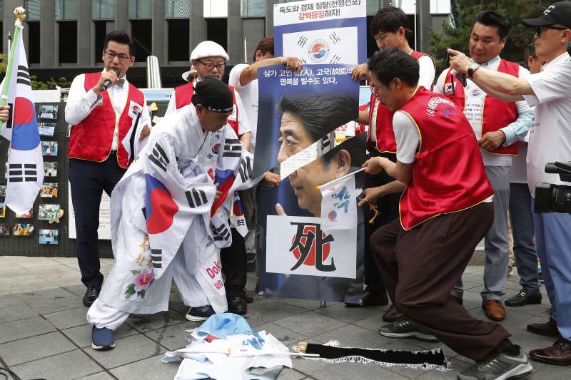 日韓貿易戰越演越烈，南韓民眾破壞印有日相安倍晉三的海報。（AP）