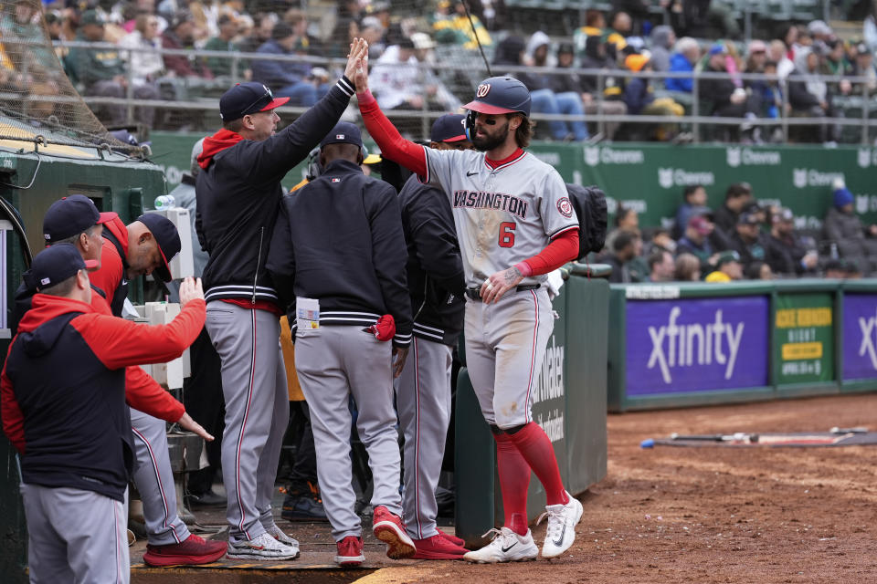 Washington Nationals' Jesse Winker (6) celebrates with teammates at the dugout after scoring against the Oakland Athletics on Luis García Jr.'s double during the sixth inning of a baseball game Saturday, April 13, 2024, in Oakland, Calif. (AP Photo/Godofredo A. Vásquez)