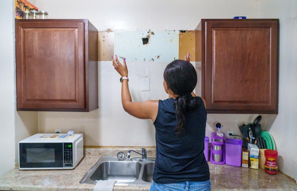 Multiple holes in drywall are seen Thursday, July 20, 2023, inside the kitchen of Vinebrook Homes renter Ayanna White (pictured). White's home, which sits on the east side of Indianapolis, has had numerous issues including an over-the-sink cabinet falling off the wall and onto the head of White. The screws used to hold the cabinet in place completely pulled from the wall. The cabinet still sits unmounted atop White's washer and dryer.