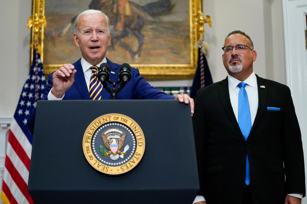 President Biden speaks about student loan debt forgiveness in the Roosevelt Room of the White House, Wednesday, Aug. 24, 2022, in Washington. Education Secretary Miguel Cardona listens at right. 