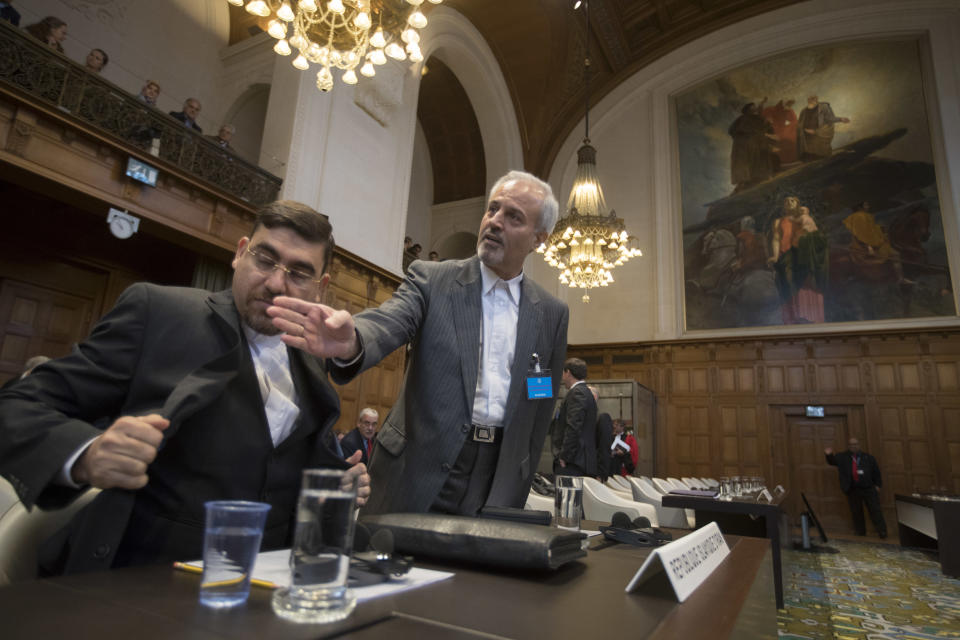 Mohammed Zahedin Labbaf, center, agent for the Islamic Republic of Iran, waits for judges to enter the International Court of Justice, or World Court, in The Hague, Netherlands, Wednesday, Oct. 3, 2018, where judges ruled on an Iranian request to order Washington to suspend U.S. sanctions against Tehran. (AP Photo/Peter Dejong)