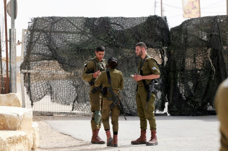Israeli soldiers are pictured at the gate of the Mount Harif military base near the city of Mitzpe Ramon in Israel's southern Negev desert, adjacent to the border with Egypt