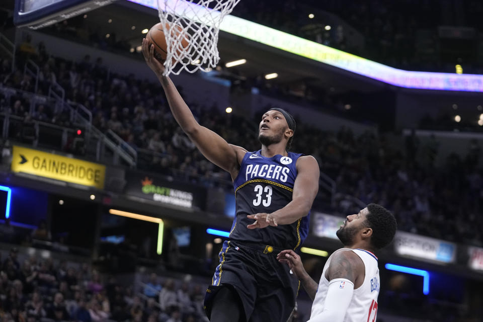 Indiana Pacers center Myles Turner (33) shoots over LA Clippers' Paul George (13) during the first half of an NBA basketball game, Saturday, Dec. 31, 2022, in Indianapolis. (AP Photo/Darron Cummings)