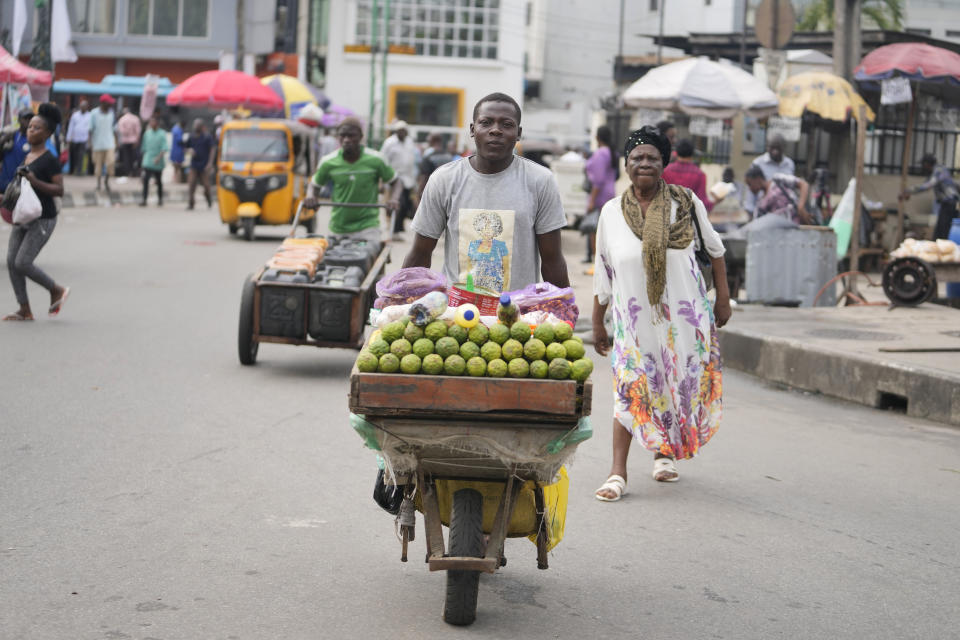 A man wheels a barrow with lemons on the streets of Lagos, Nigeria, Tuesday, Sept. 5, 2023. (AP Photo/Sunday Alamba)