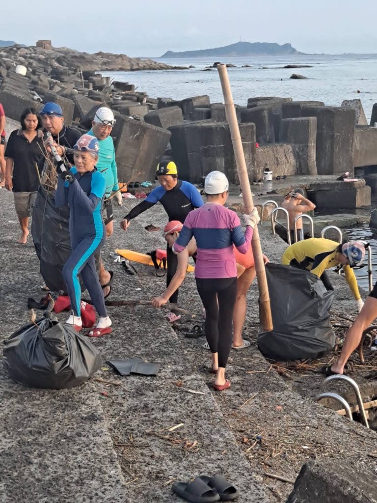 海興游泳池的泳客看到志工淨灘，也一起動手撿海邊的垃圾，清出近二千公斤的海廢。（記者張上耕攝）