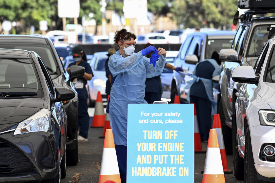 Health care workers administer COVID-19 tests at a drive-through clinic in Sydney, Friday, Dec. 31, 2021. Australian health authorities have reported a record 32,000 new virus cases, many of them in Sydney. (Bianca De Marchi/AAP Image via AP)