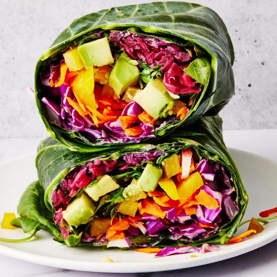 collard green wrap filled with shredded purple cabbage, grated carrots, yellow bell pepper, avocado, alfalfa sprouts and red sauerkraut