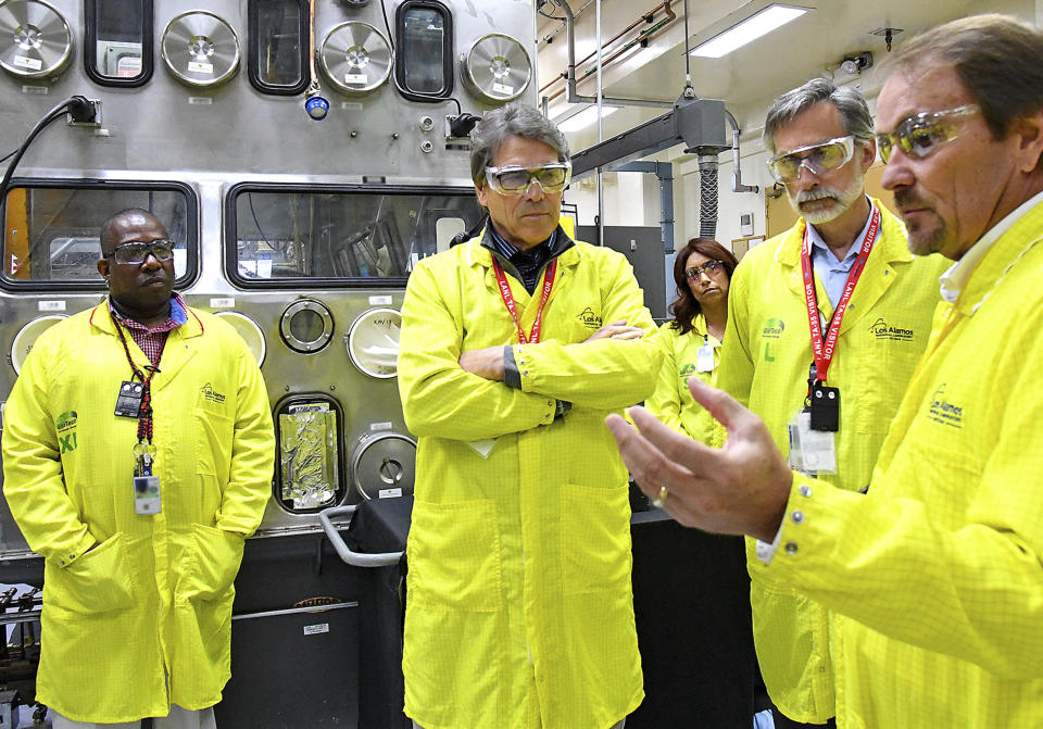 FILE - In this May 10, 2017, file photo provided by the Los Alamos National Laboratory, U.S. Secretary of Energy Rick Perry, second from left, accompanied by Laboratory Director Charlie McMillan, second from right, learns about capabilities at the Los Alamos Laboratory Plutonium Facility, from Jeff Yarbrough, right, Los Alamos Associate Director for Plutonium Science and Manufacturing, in Los Alamos. A federal appeals court has ruled against Nevada in a legal battle over the U.S. government's secret shipment of weapons-grade plutonium to a site near Las Vegas. A three-judge panel of the 9th U.S. Circuit Court of Appeals on Tuesday, Aug. 13, 2019, denied the state's appeal after a judge refused to block any future shipments to Nevada. The court in San Francisco says the matter is moot because the Energy Department already sent the radioactive material and has promised that no more will be hauled there. (Los Alamos National Laboratory via AP, File)