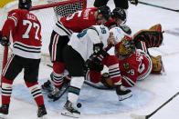 San Jose Sharks center Logan Couture (39) battles for the puck against Chicago Blackhawks defenseman Connor Murphy (5) and goaltender Marc-Andre Fleury (29) during the second period of an NHL hockey game in Chicago, Sunday, Nov. 28, 2021. (AP Photo/Nam Y. Huh)